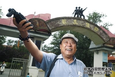 北京電影廠外，趙士軒用閃光燈打亮自己。平時，他都坐在這里等待演戲機會。趙士軒曾是一名法官，退休后為圓演戲夢，成為北影廠門口的一名群演。