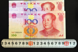 “加長(zhǎng)版”百元鈔票對(duì)比，明顯比其它鈔票長(zhǎng)一點(diǎn)，防偽線和字體的位置也不同。