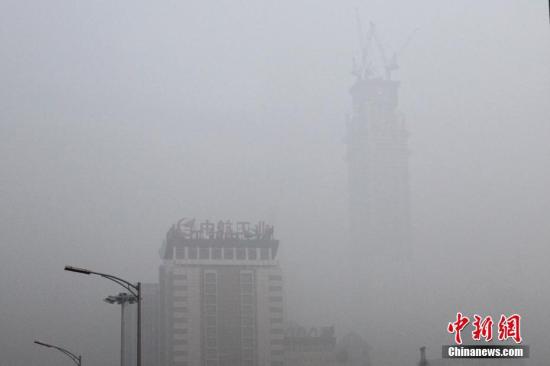 12月20日，北京CBD高樓在霧霾籠罩下若隱若現(xiàn)。中新社記者 富田 攝