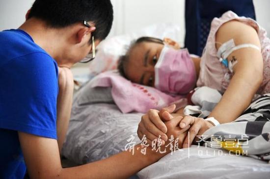 躺在病床上的母親緊緊地牽著兒子的手臂，眼神里有太多的牽掛和不舍。